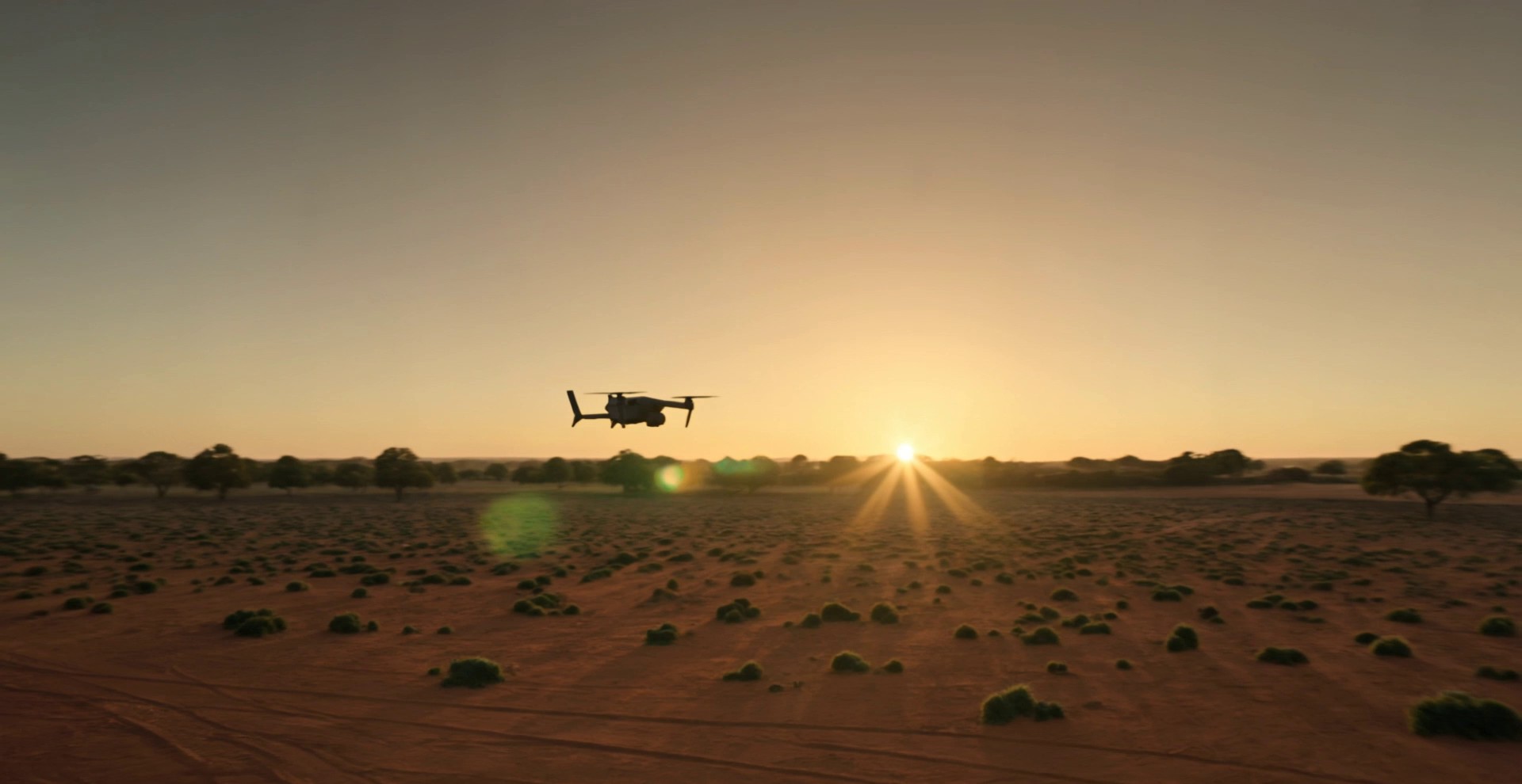 Autonomous drone on station over outback terrain at sunset